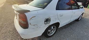 Другие автомобили: Белый седан компакт‑класса с передним приводом. Кузов 4‑дверный, на — 4