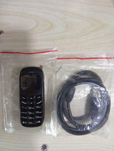 agdas telefon: Qara rəngli, düyməli idarəetməyə malik kiçik ölçülü mobil telefon və