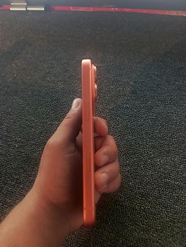 iphone 16e azerbaycan: Narıncı rəngdə smartfon (iPhone dizaynlı), arxa paneldə üçlü kamera — 3
