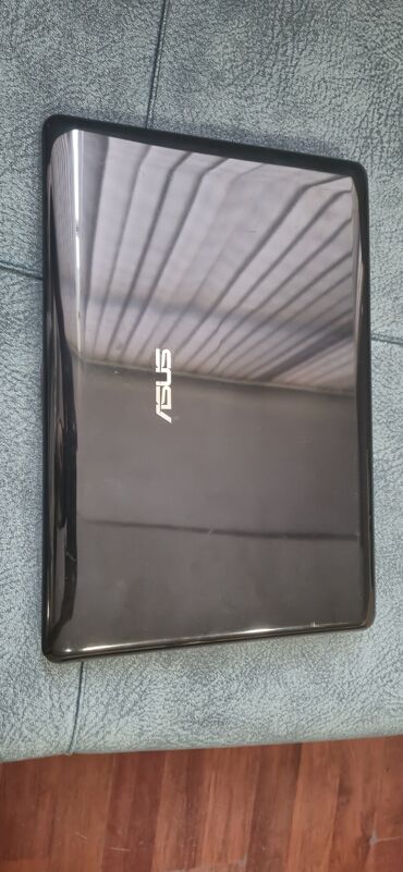 ASUS brendinə məxsus qara rəngli noutbuk. Üst qapağında "ASUS" loqosu