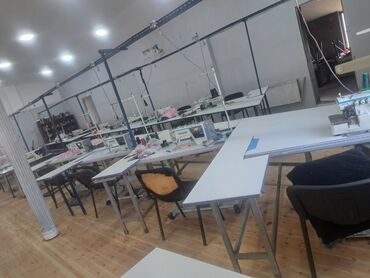 Bu şəkil tikiş emalatxanasında olan bir sıra tikiş maşınlarını, iş