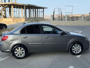 Tavalar: Kia Rio markalı, boz rəngli sedan avtomobil. Təkərləri yaxşı