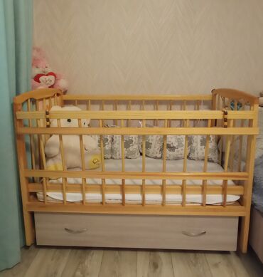 Детские кровати: Кроватка детская. Сделана из дерева. Высокий и низкий бортик, высокое