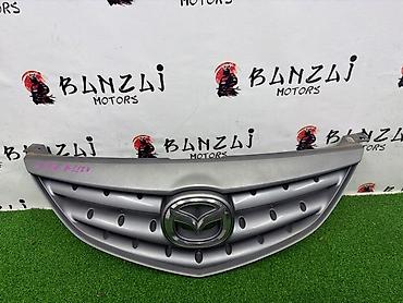 mazda 2000: Решетка радиатора Mazda 2004 г., Б/у, Оригинал — 2