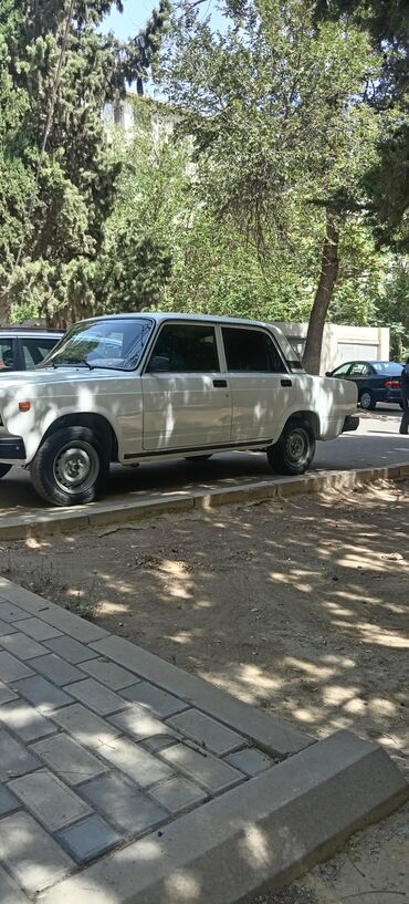 qazel yuk maslnl: Bu, dörd qapılı, ağ rəngli sedan avtomobilidir. Avtomobilin kənarında