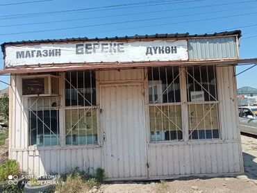с байтик дом: Металлический киоск белого цвета с двускатной крышей. На фасаде