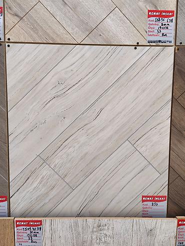 Ağ-açıq boz tonlarda, taxta teksturasını xatırladan laminat döşəmə