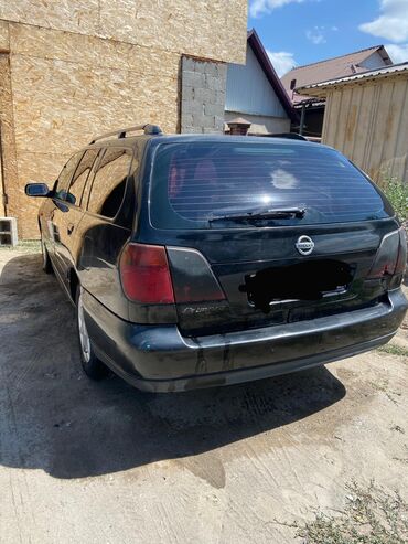 приматок прямоток: Универсал Nissan Primera в черном цвете. Автомобиль имеет характерный