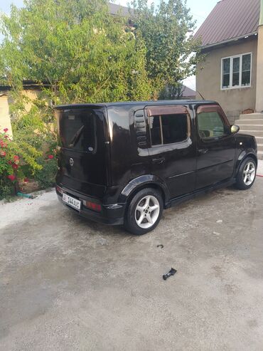 купить диск на машину: Компактный автомобиль Nissan Cube в черном цвете, идеально подходящий