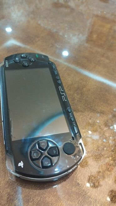 псп го купить: Sony PSP-1000 modelindən olan qara rəngli daşınabilən oyun konsolu