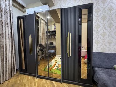 Мебель: Qara rəngli, güzgülü qapıları olan müasir üslubda dolab. Dolab yataq
