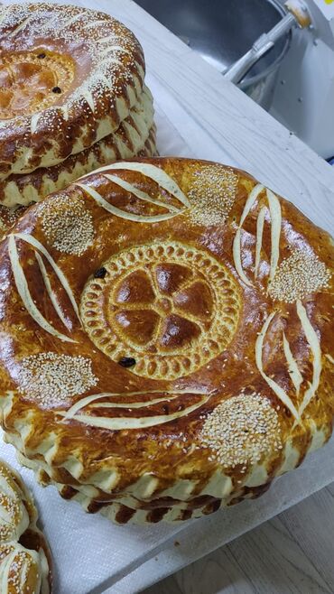 Выпечка, хлебобулочные изделия: Свежеиспеченный узбекский хлеб круглой формы, украшенный характерными — 9