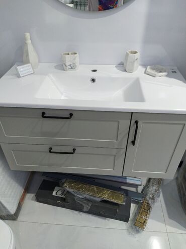 toxunma tutacaqlar: Ağ rəngli keramika lavabo və boz rəngli rəfli şkafdan ibarət hamam