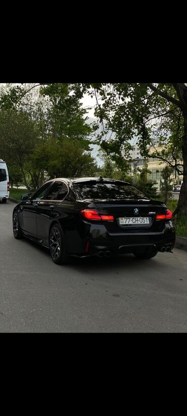 Arxa hissədən çəkilmiş qara rəngli BMW M5 sedan avtomobili
