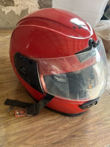 Moto dəbilqələr: Qırmızı rəngdə, şəffaf vizorlu motosiklet dəbilqəsi. Başı qorumaq üçün