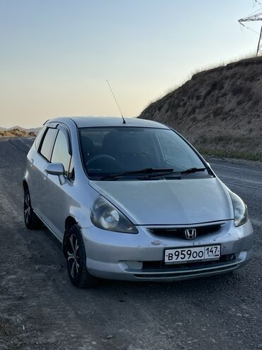 маленькая машина: Серебристый хэтчбек Honda Fit с пятидверным кузовом, идеально