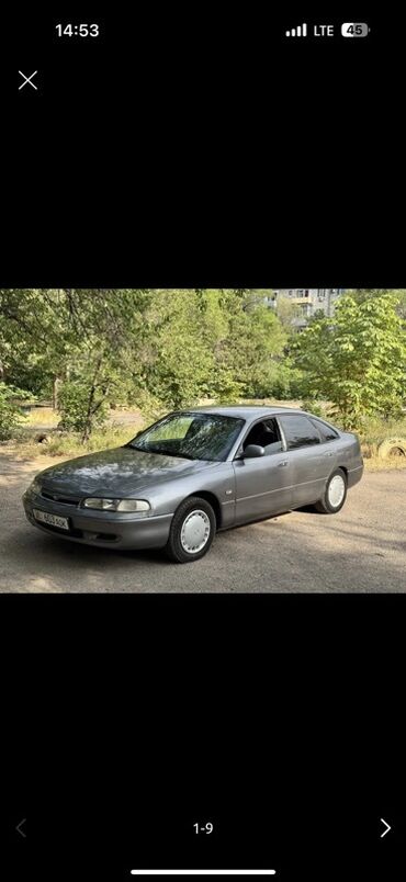 авто уна: Автомобиль Mazda 626 седан серого цвета. Эта модель известна своей