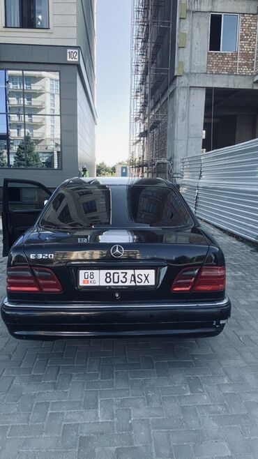 авто лизинг рассрочка: Черный седан Mercedes-Benz E320, оснащенный номерным знаком