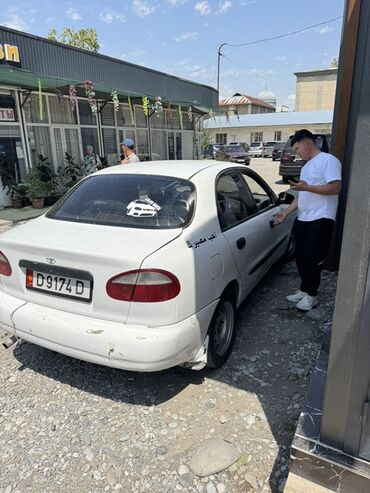 семёрка машина: Белый седан Daewoo Lanos с четырьмя дверями. Автомобиль оснащен