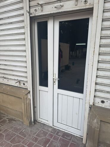 Двери жалюзи: Ağ rəngli, ikiqat şüşəli PVC qapı. Bu qapı iki qapı qanadı ilə yanaşı