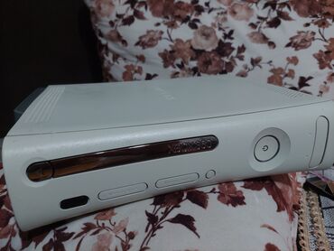 Ağ rəngdə "Xbox 360" konsolu. Model "Fat" gövdə tipinə malikdir. Disk