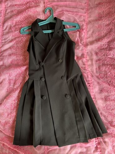 Костюмы: Bu qara rəngli qadın blazer donu qolsuz dizaynı ilə seçilir. V formalı