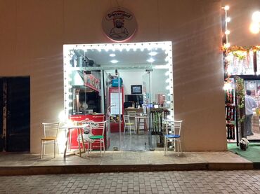 Popkorn aparatları: Dönərlər təklif edən kiçik restoran. Aydın şəkildə işıqlandırılmış