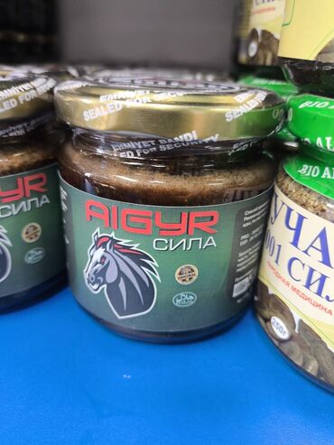 темир столдор: Стеклянная банка с продуктом "AIGYR СИЛА" имеет золотистую