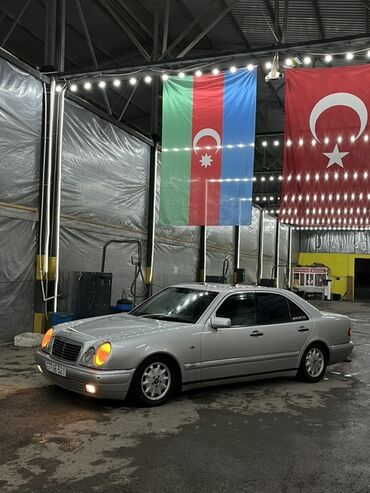 Mercedes-Benz: Gümüşü rəngli Mercedes-Benz E-Class sedanı. Avtomobil rahat və
