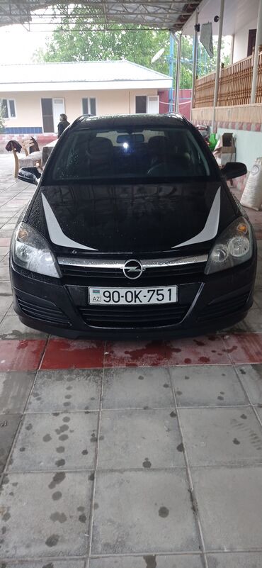 Opel: Qara rəngdə olan Opel Astra universal avtomobili. Avtomobilin ön — 2