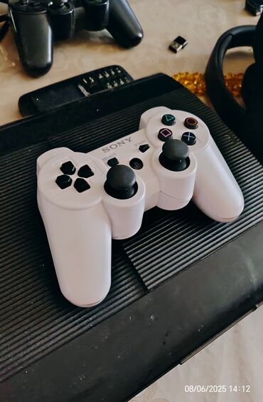 PS3 (Sony PlayStation 3): Ağ rəngdə olan Sony PlayStation 3 üçün simsiz idarəetmə pultu. Bu pult