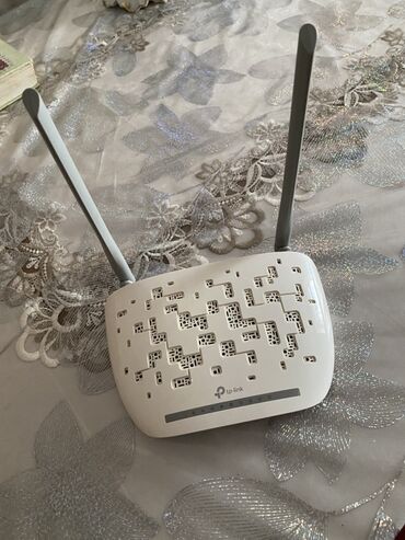 Monitorlar: TP-Link markalı, ağ rəngli simsız router. İki antenası və hava