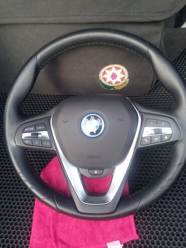 Dəri örtüklü, çoxfunksiyalı qara BMW sükan. Sükanın mərkəzində BMW