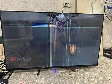 LED телевизор 43" (примерно) с тонкими рамками и ножками-подставками