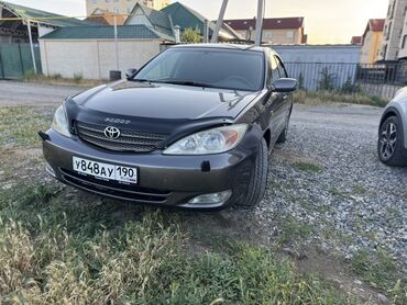 Toyota: Автомобиль Toyota Camry в кузове седан, окрашенный в серый цвет. На