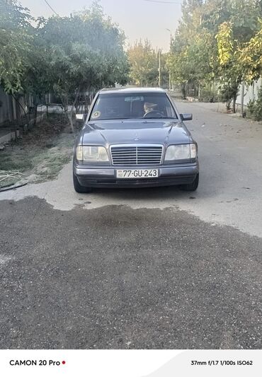 Su nəqliyyatı: Mercedes-Benz E-Class sedanı, qaranlıq boz rəngdədir və geniş radiator
