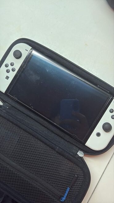 Nintendo Switch: Ağ rəngli Nintendo Switch OLED modeli. Oyun konsolu qara rəngli