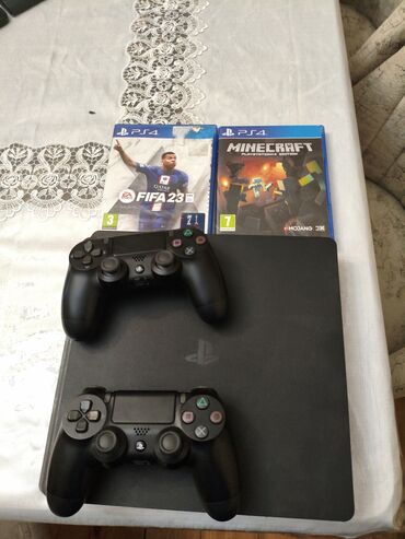 plesdesn: Qara rəngli PlayStation 4 Slim oyun konsolu. İki ədəd DualShock 4