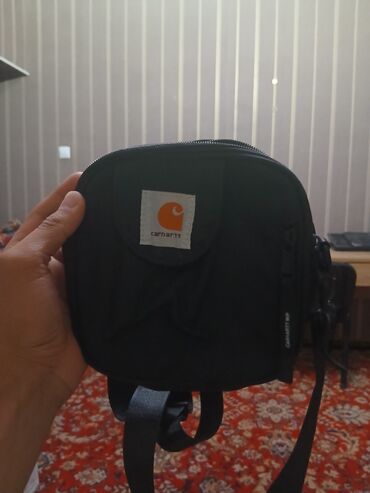 срочно продаю в связи с переездом: Сумка через плечо Carhartt черного цвета. Компактная круглая форма