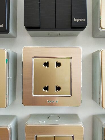 Generatorlar: Legrand markalı, qızılı rəngli dörd çıxışlı elektrik rozetkası. Evdə