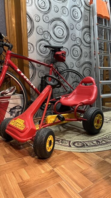 Oyuncaqlar: Uşaqlar üçün pedallı qırmızı rəngli kart. Bu kart plastik oturacaq və