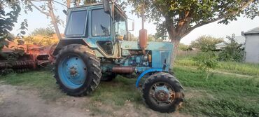 Traktorlar: Mavi rəngli, iri təkərli traktor. Kənd təsərrüfatı işləri üçün