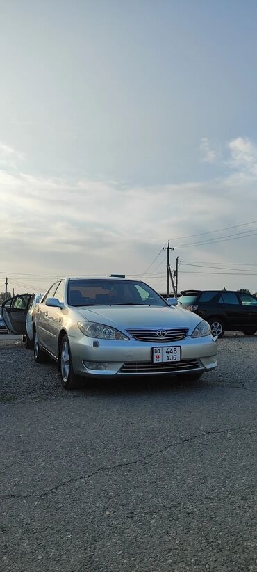 Toyota: Автомобиль Toyota Camry серебристого цвета. Седан среднего размера с