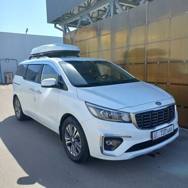 семиместные машины: Белый минивэн Kia Carnival с просторным салоном и дополнительным