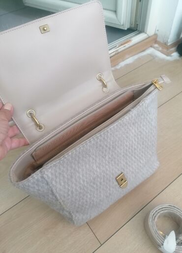 Torbe: Ženska torba sa preklopom od veštačkog krzna u bež boji. Torba ima dve — 11