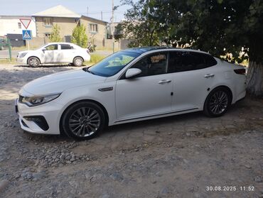 зарядка на авто: Белый седан Kia Optima с глянцевой черной крышей и панорамным люком