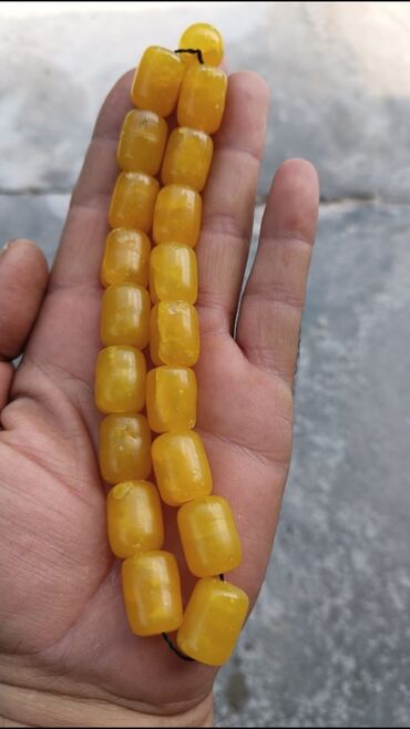 Dairəvi küncləri olan silindrik formalı kəhrəba muncuqlarla