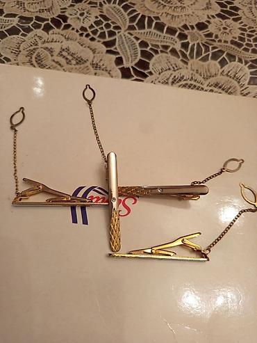 qizil sat: Zəncirli, qızılı rəngli metal qalstuk sancaqları. Bu dəstə bir neçə — 4