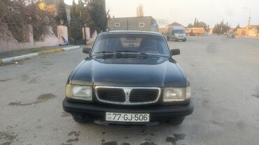 Ön hissəsində şaquli xrom detalları olan qara rəngli sedan avtomobili