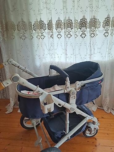 uşaq arabası ucun mufta: Tünd göy rəngdə uşaq arabası. Ağ çərçivəli konstruksiyaya malikdir və — 2